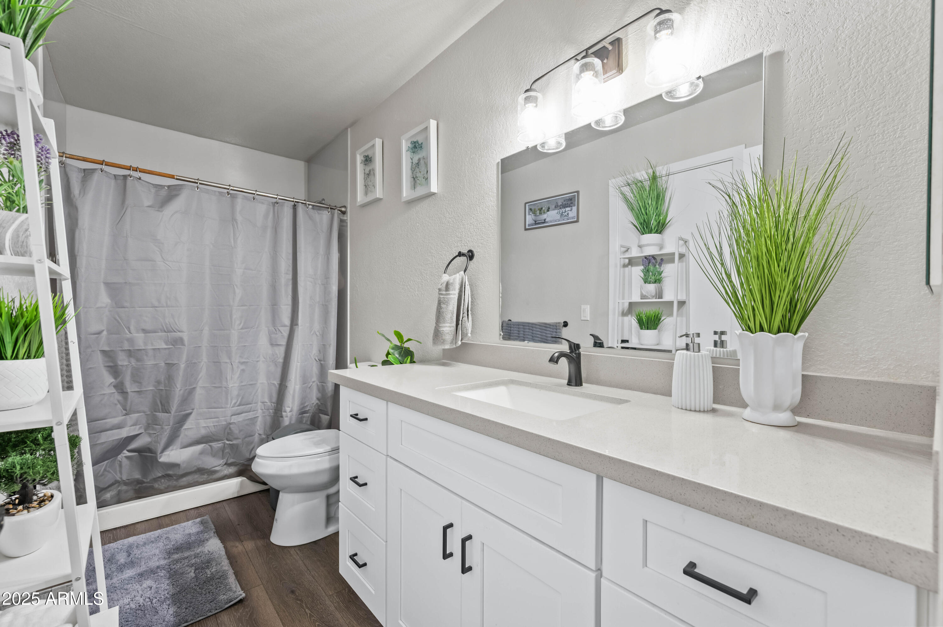 7231 West Flower Street Phoenix, AZ 85033 - Photo 13 of 17 a bathroom with a granite countertop sink a toilet a mirror and shower