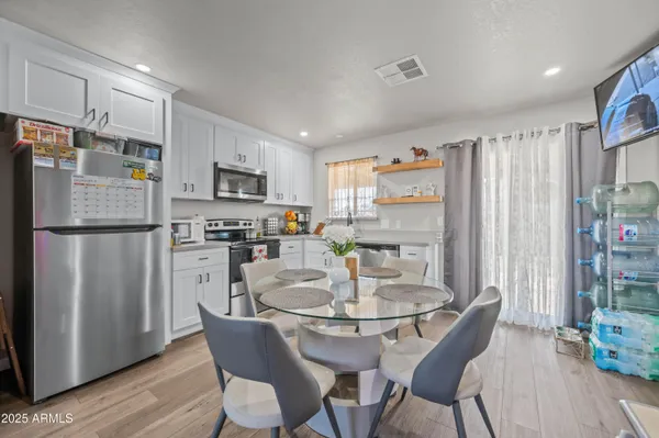 a kitchen with stainless steel appliances granite countertop a dining table and chairs