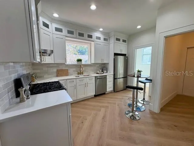 a kitchen with a sink a counter top space cabinets and stainless steel appliances