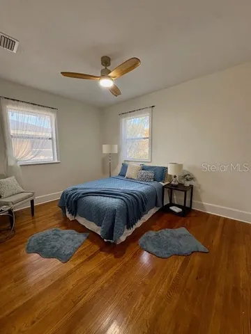 a bedroom with a bed and wooden floor