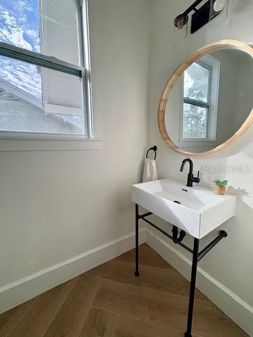 a bathroom with a sink a mirror and a window