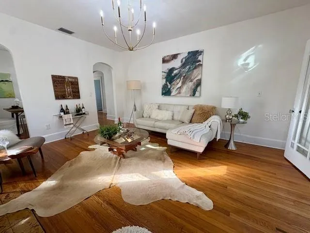 a living room with furniture and a chandelier
