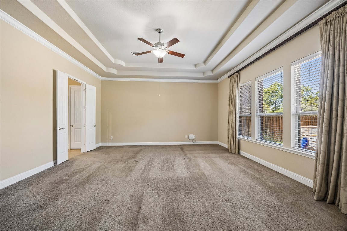 14123 Spindle Arbor Road Cypress, TX 77429 - Photo 18 of 45 Generous neutral-toned primary bedroom with tray ceiling, large windows for natural light, and expansive view of backyard.