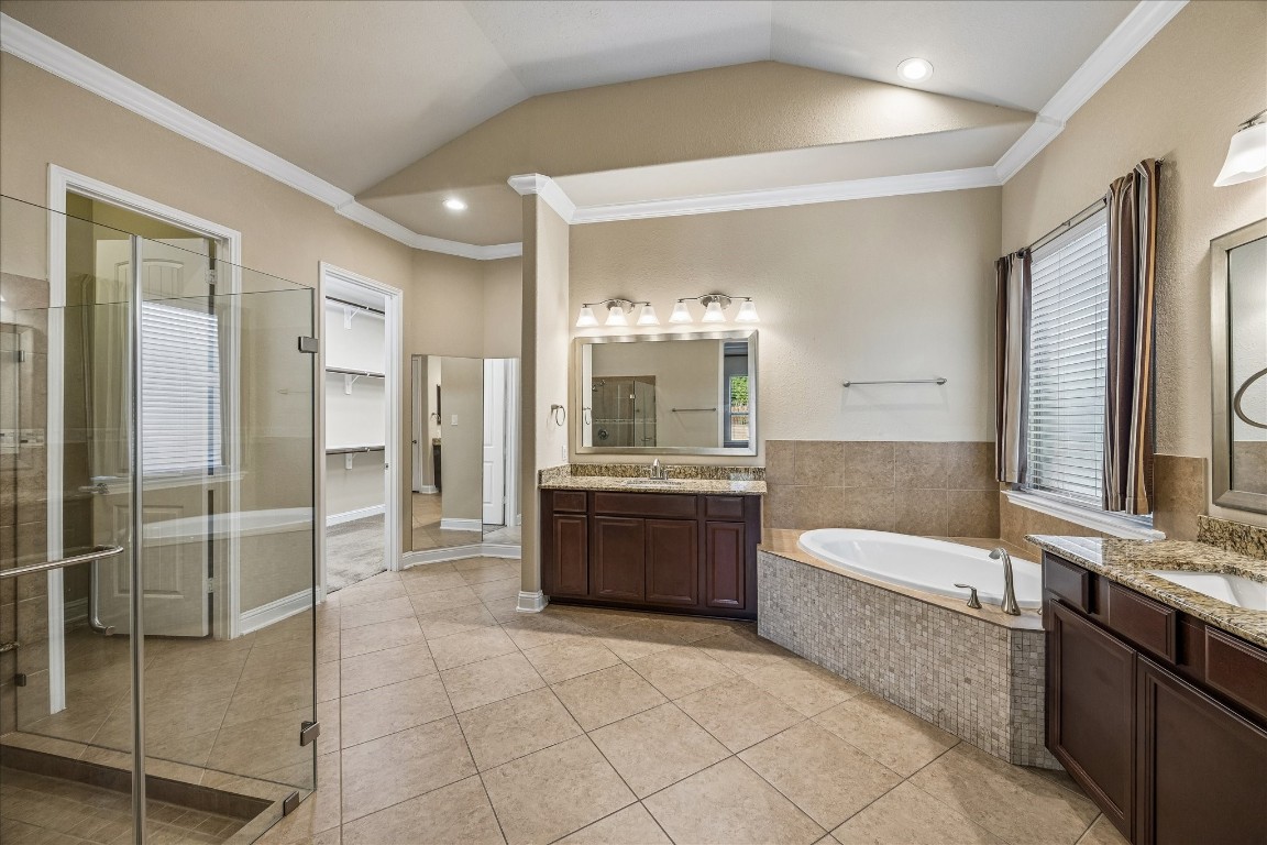 14123 Spindle Arbor Road Cypress, TX 77429 - Photo 20 of 45 Primary bathroom features a large soaking tub, a glass-enclosed shower, dual vanities with granite countertops, and ample natural light, offering a luxurious and relaxing atmosphere.
