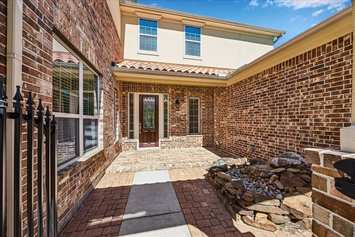 14123 Spindle Arbor Road Cypress, TX 77429 - Photo 2 of 45 Welcoming courtyard entrance with brick and pave stone is accentuated by calming water feature.