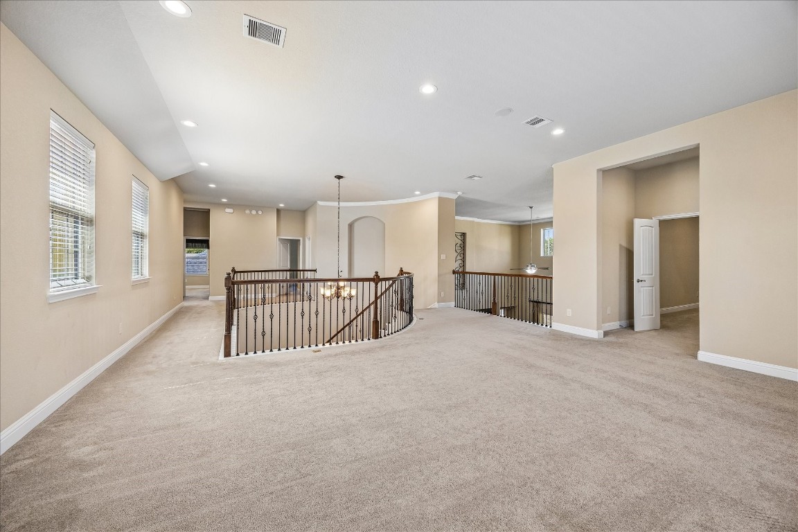 14123 Spindle Arbor Road Cypress, TX 77429 - Photo 25 of 45 Upstairs landing opens to an expansive game room with access to bedrooms and media room. It features multiple windows for natural light, a decorative iron railing overlooking a lower level creating an open and inviting space.