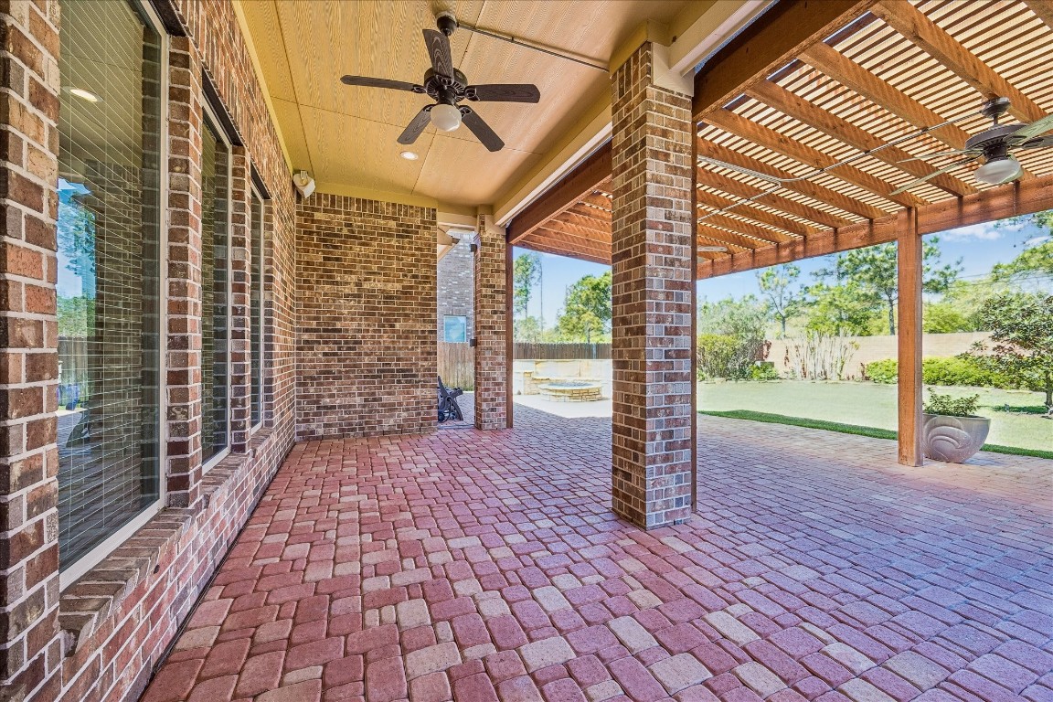 14123 Spindle Arbor Road Cypress, TX 77429 - Photo 36 of 45 Inviting covered patio with stone-pavers and view of the well manicured landscape is perfect for outdoor relaxation and entertaining. It features a pergola for added shade. Enjoy your favorite music via the outdoor speakers.