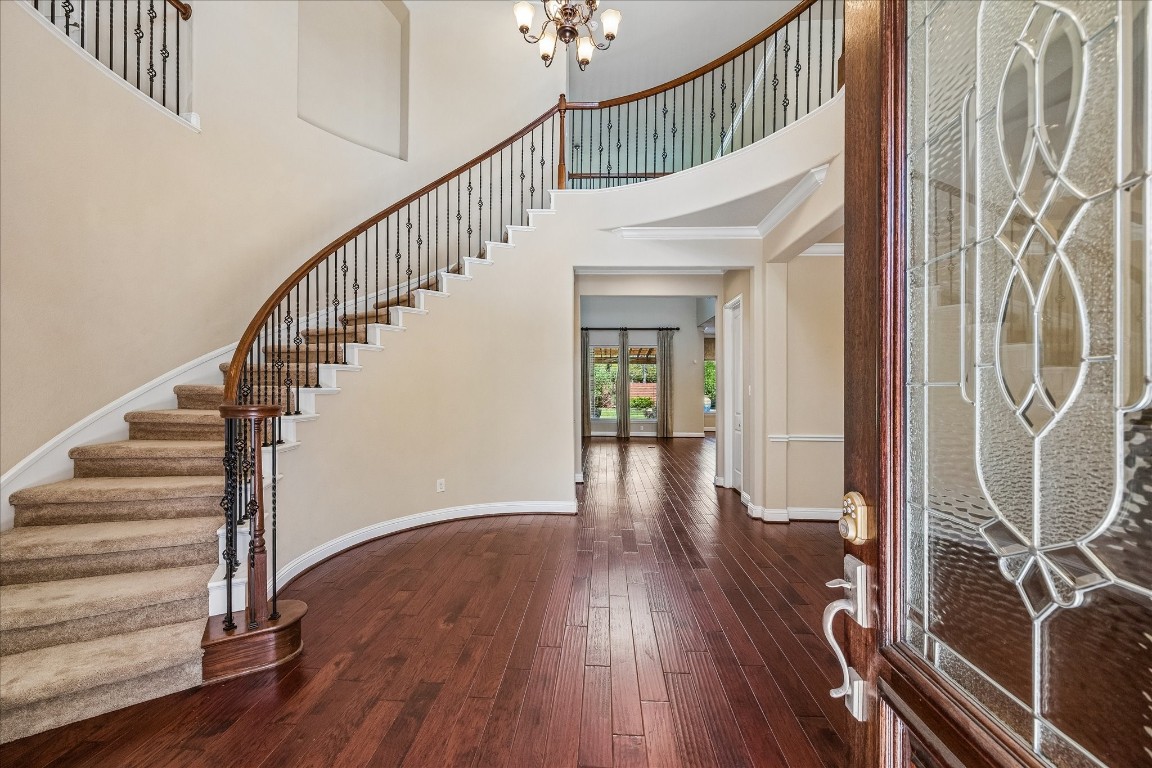 14123 Spindle Arbor Road Cypress, TX 77429 - Photo 4 of 45 A stunning curved staircase with ornate iron balusters and rich wood floors complement the open, airy layout leading to a bright, inviting living space, perfect for welcoming guests.