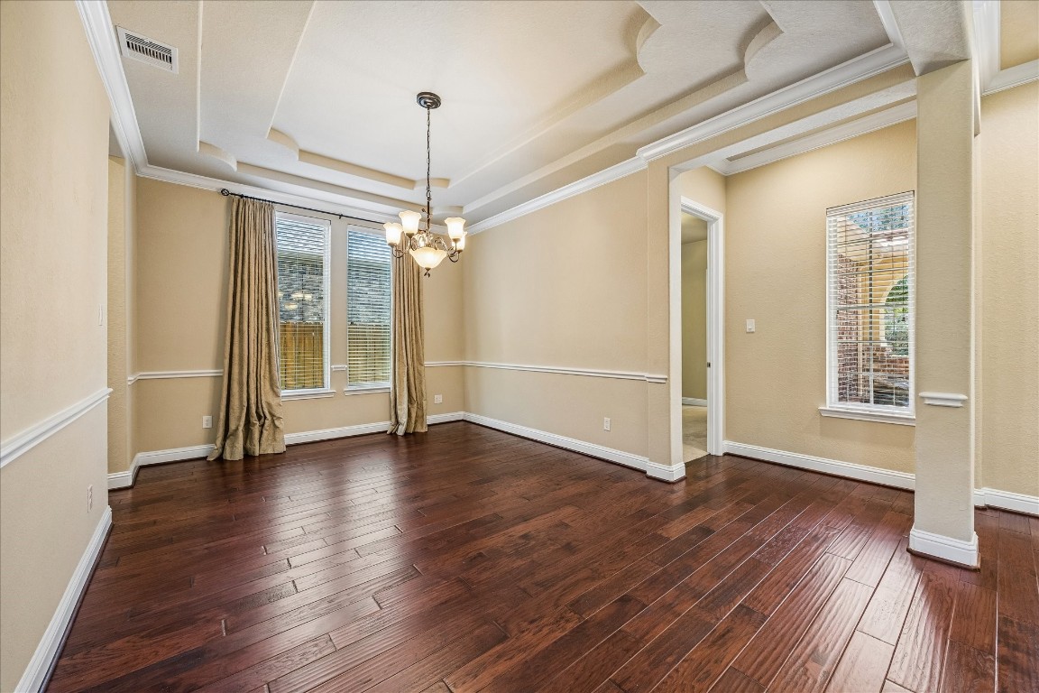 14123 Spindle Arbor Road Cypress, TX 77429 - Photo 9 of 45 Dining room includes rich hardwood floors and a stylish tray ceiling with crown molding and chair railing. Large draped windows allow plenty of natural light. Perfect for a dining area or formal sitting room.