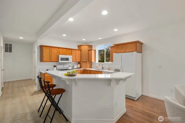 a kitchen with stainless steel appliances a table and chairs