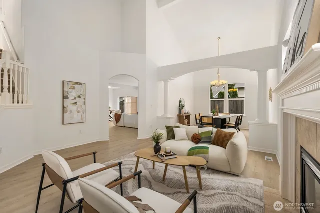 a living room with furniture a fireplace and a large window