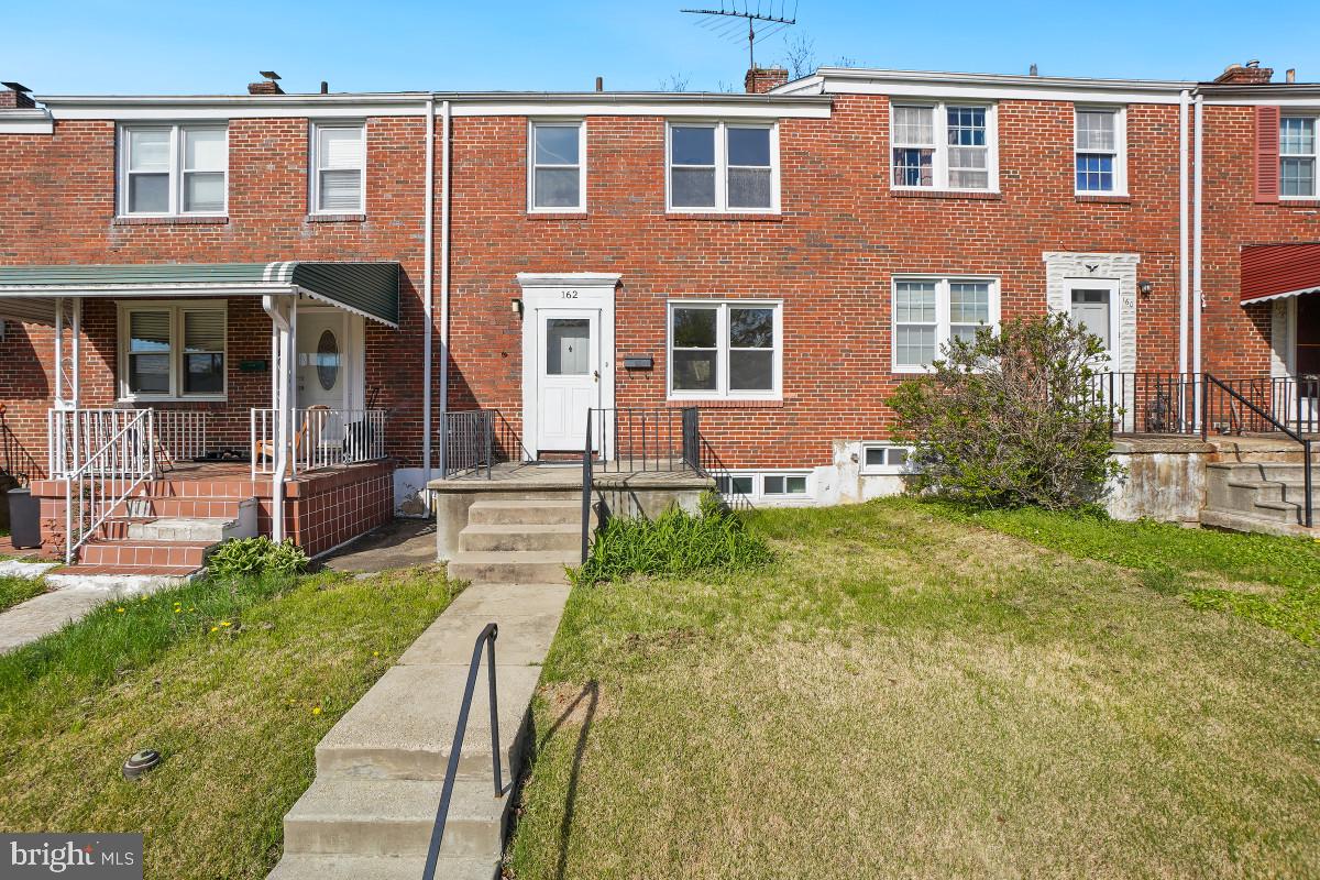 Charming brick townhome with greenery.