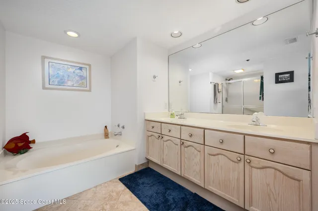 a spacious bathroom with a tub sink and mirror