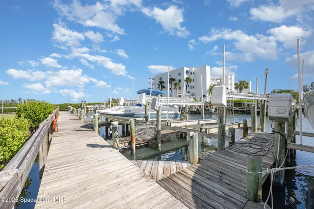 a view of a rooftop deck with chairs and wooden floor