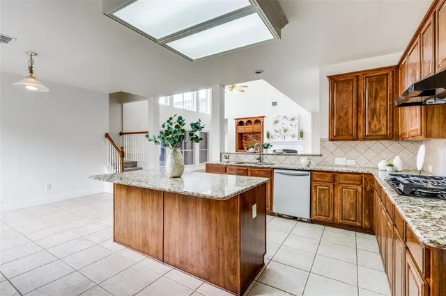 a kitchen with stainless steel appliances granite countertop a sink counter space cabinets and a stove