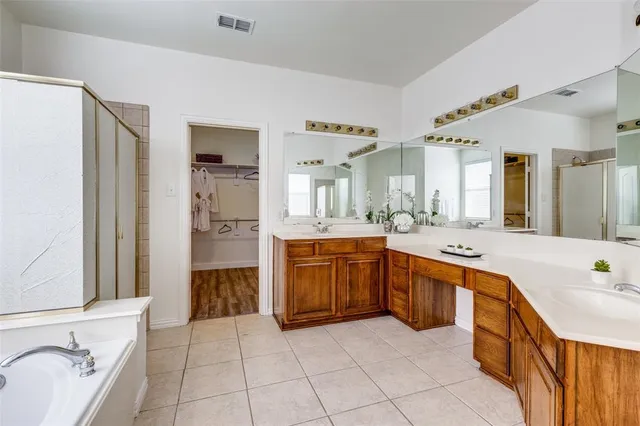a large bathroom with a tub a sink and a large mirror