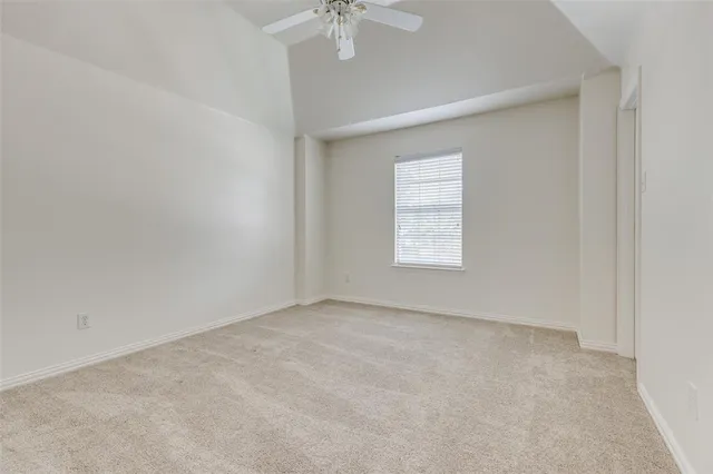 an empty room with a window and a ceiling fan