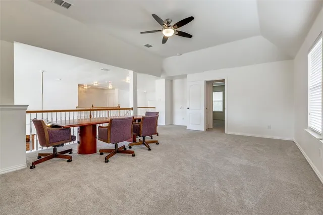 a view of a workspace with furniture and a ceiling fan