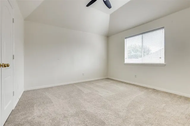 an empty room with a window and a ceiling fan