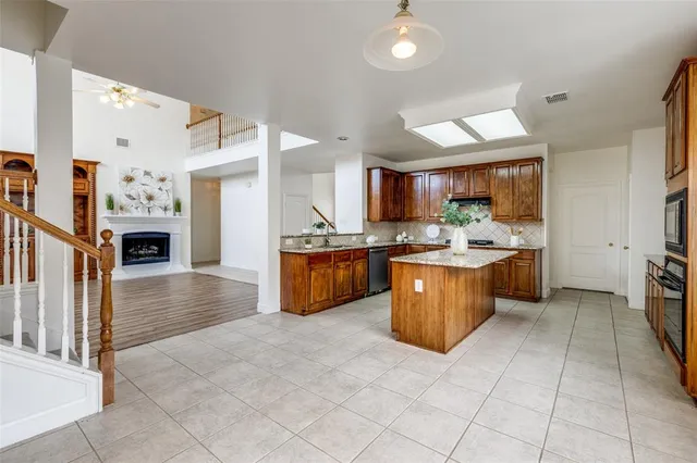 a kitchen with stainless steel appliances granite countertop a stove top oven a sink a counter top space and cabinets