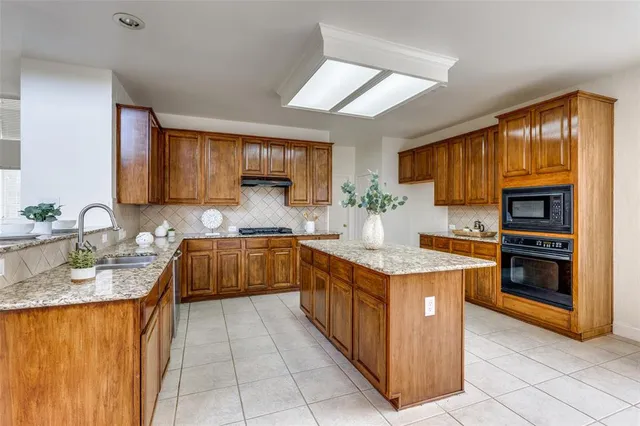 a kitchen with stainless steel appliances granite countertop wooden cabinets a sink and dishwasher
