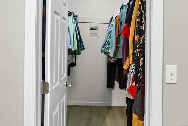 a view of walk in closet with clothes and shoes