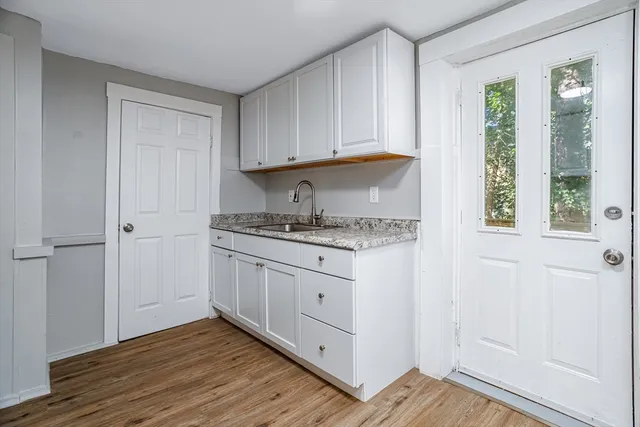 a kitchen with granite countertop white cabinets and white appliances