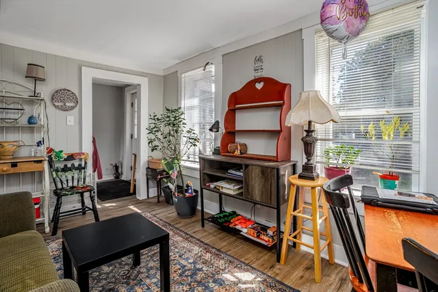 a living room with furniture a flat screen tv and a window