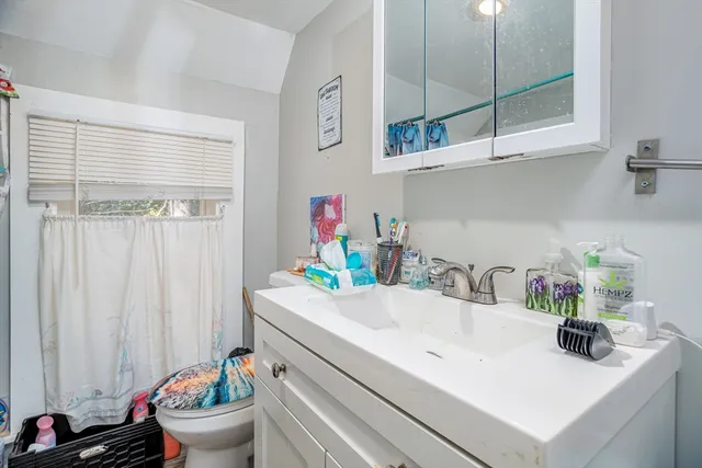 a bathroom with a sink a toilet and a window