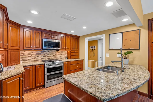 a kitchen with kitchen island granite countertop wooden cabinets and a refrigerator