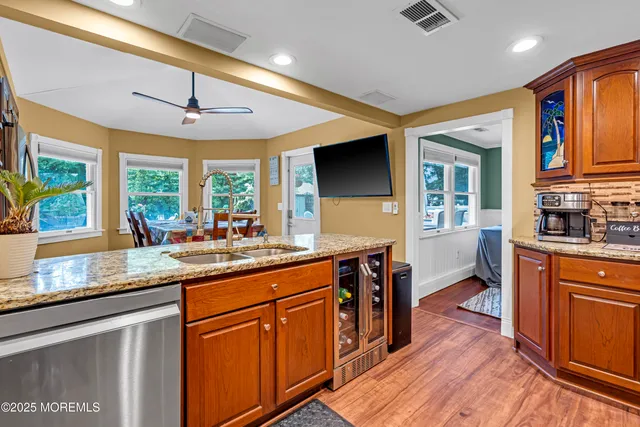 a kitchen with stainless steel appliances granite countertop sink stove top oven and cabinets