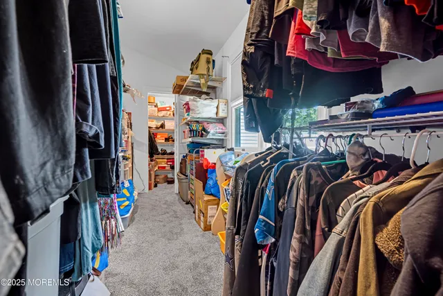 a view of walk in closet with clothes and shoes