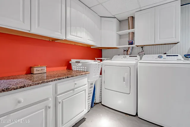 a utility room with cabinets and washer