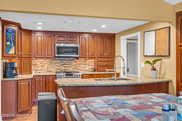a kitchen with stainless steel appliances granite countertop a sink stove and cabinets