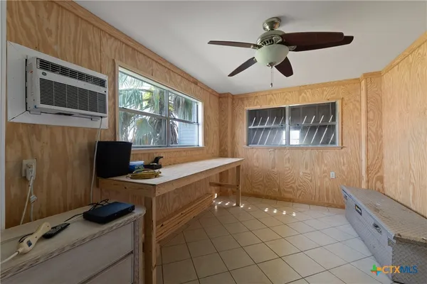 a view of a workspace with furniture and a window