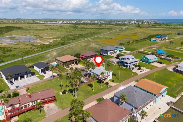 a front view of a house with plants and palm tree