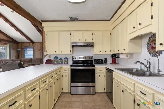 a kitchen with stainless steel appliances granite countertop a sink and cabinets