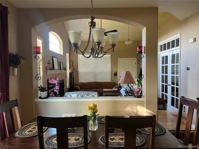 a room with table chairs and wooden floor