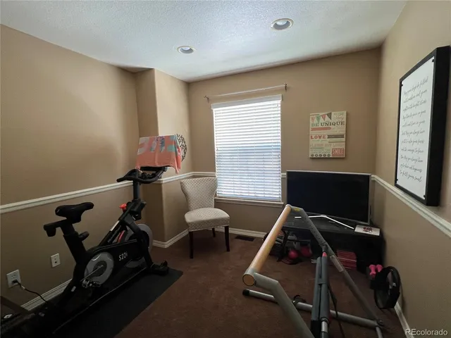 a room with gym equipment on the wall and a window