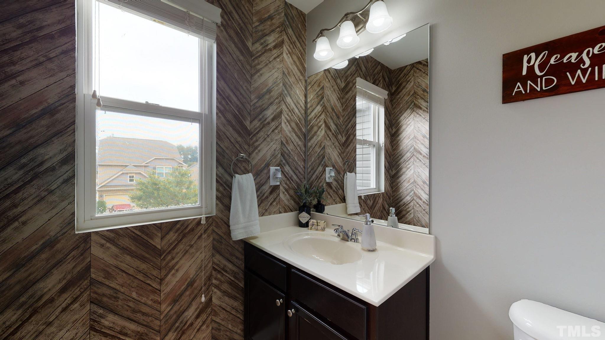 3558 Eastern Branch Road Raleigh, NC 27610 - Photo 25 of 25 a bathroom with a sink a mirror and a window
