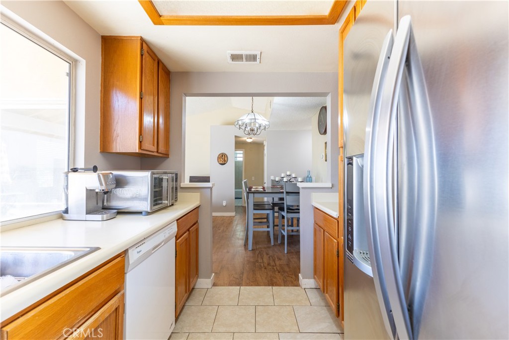 42015 Cosmic Drive Temecula, CA 92592 - Photo 8 of 27 a kitchen with granite countertop a sink and a refrigerator