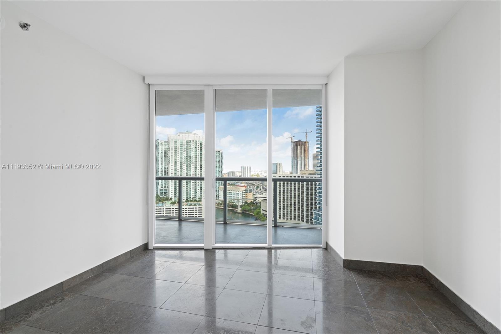465 Brickell Avenue, Unit 2604 Miami, FL 33131 - Photo 4 of 23 an empty room with sliding glass door and windows