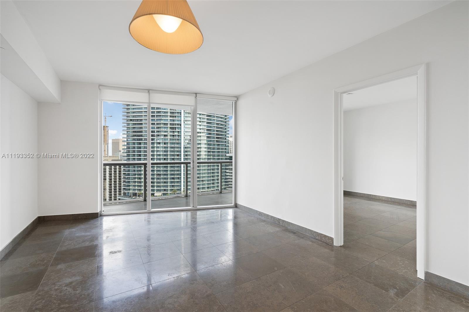 465 Brickell Avenue, Unit 2604 Miami, FL 33131 - Photo 9 of 23 an empty room with wooden floor and windows