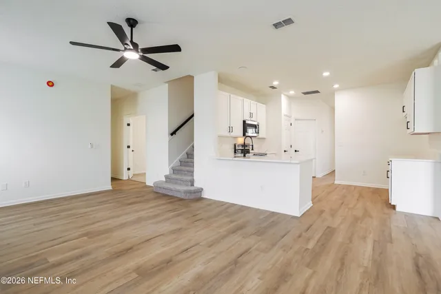 a view of a kitchen with a sink and wooden floor
