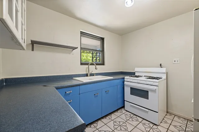 a kitchen with a stove sink and window