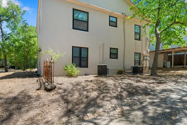 a view of a house with backyard and trees