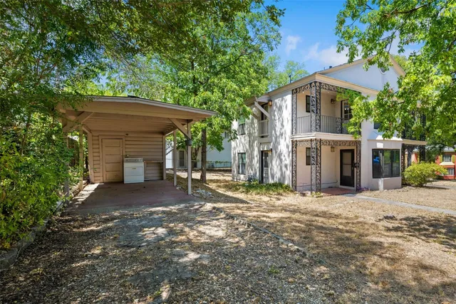 a front view of a house with yard and trees