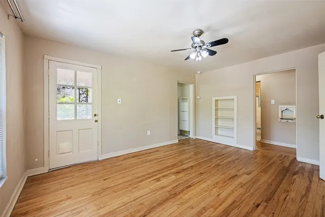 a view of empty room with wooden floor
