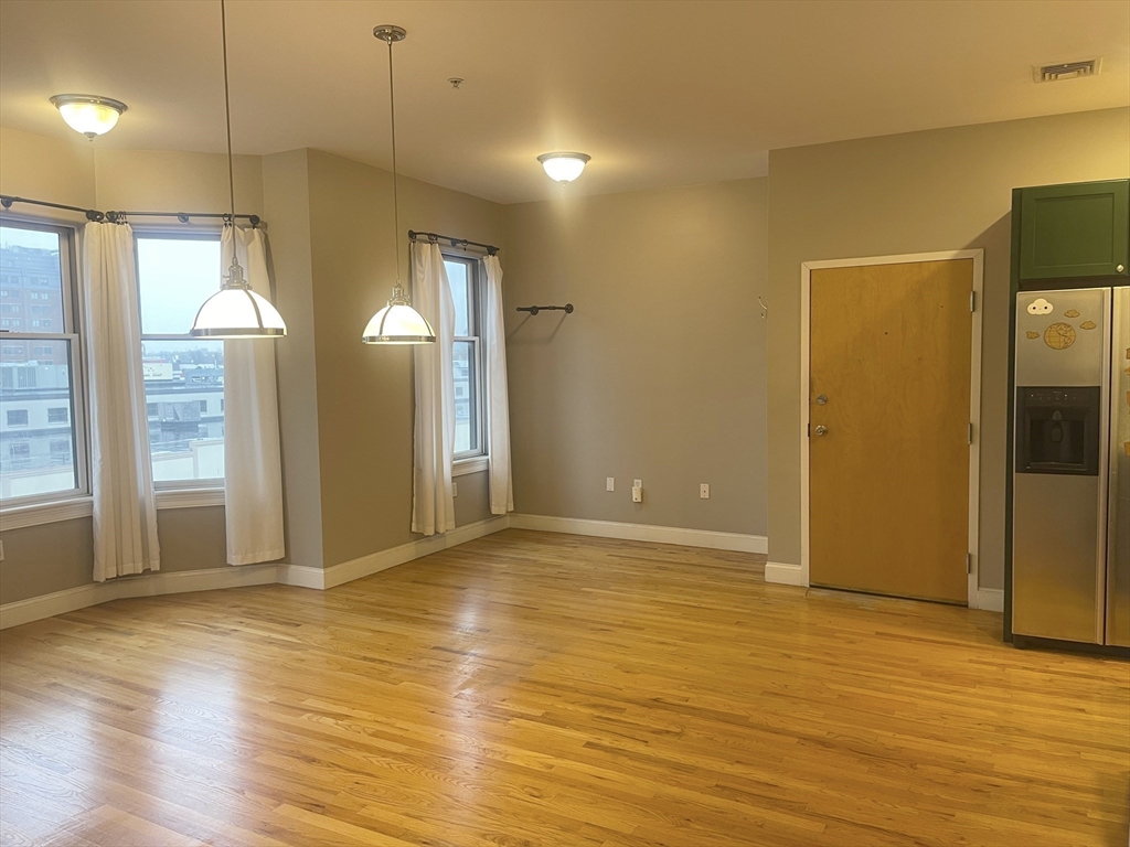 877 Harrison Avenue, Unit 6 Boston, MA 02118 - Photo 3 of 9 a view of an empty room with window and wooden floor
