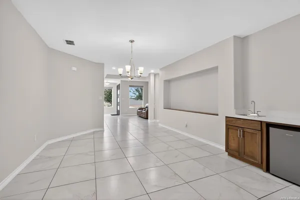a view of a livingroom with a chandelier furniture and kitchen view